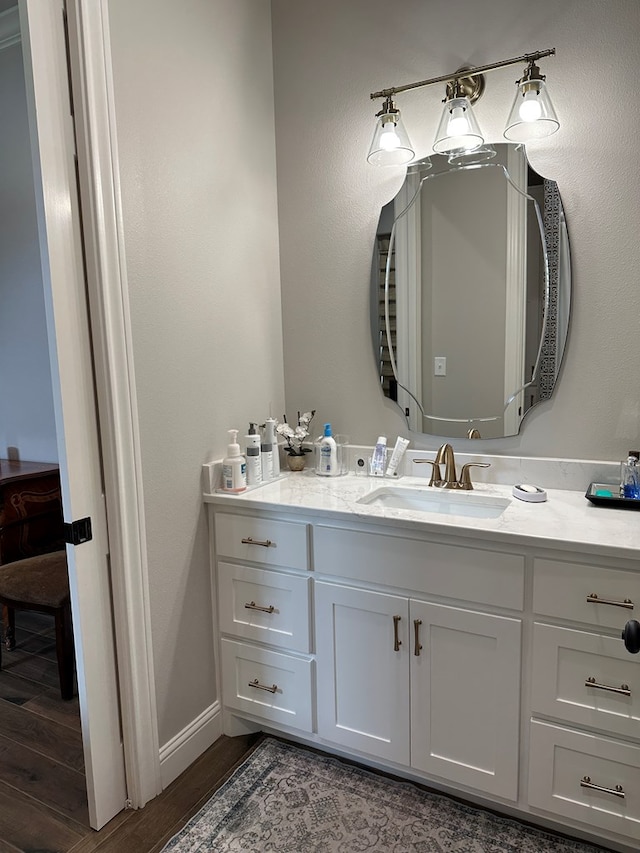 1733 Overhill Dr, San Angelo, TX 76904 - bathroom featuring vanity, wood finished floors, and baseboards