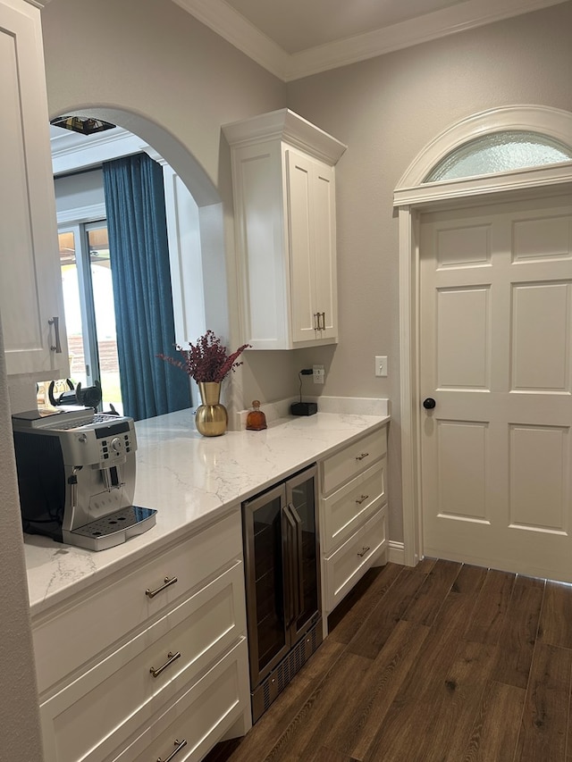 1733 Overhill Dr, San Angelo, TX 76904 - bar area with wine cooler, dark wood-style floors, ornamental molding, and arched walkways