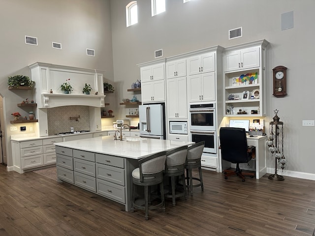 1733 Overhill Dr, San Angelo, TX 76904 - kitchen with open shelves, white appliances, gray cabinetry, a towering ceiling, and a sink