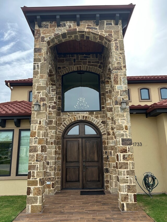 1733 Overhill Dr, San Angelo, TX 76904 - doorway to property featuring stucco siding, stone siding, and a tiled roof