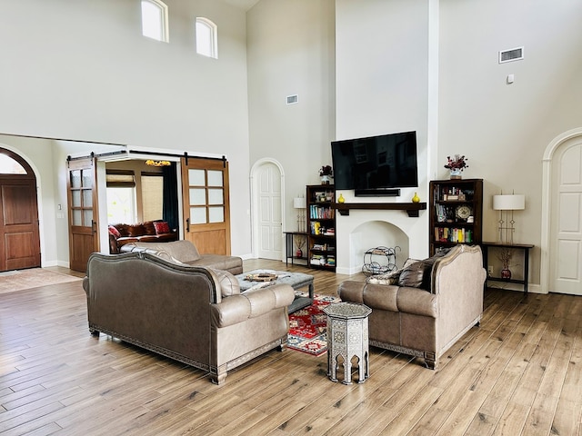 1733 Overhill Dr, San Angelo, TX 76904 - living room with a high ceiling, light wood finished floors, arched walkways, and baseboards