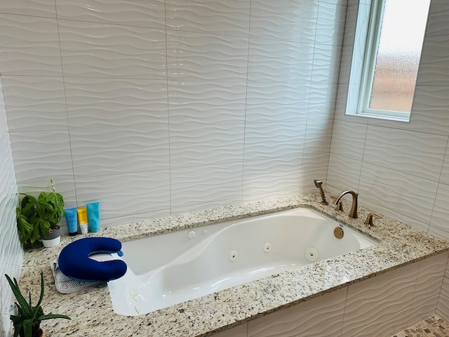 1733 Overhill Dr, San Angelo, TX 76904 - bathroom with a tub with jets and tile walls