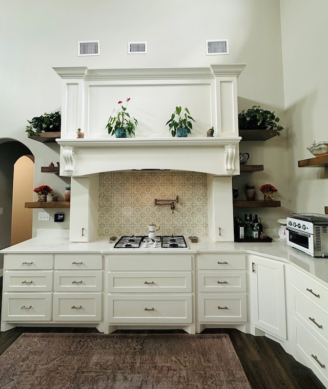 1733 Overhill Dr, San Angelo, TX 76904 - kitchen featuring open shelves, white gas cooktop, arched walkways, decorative backsplash, and white cabinets