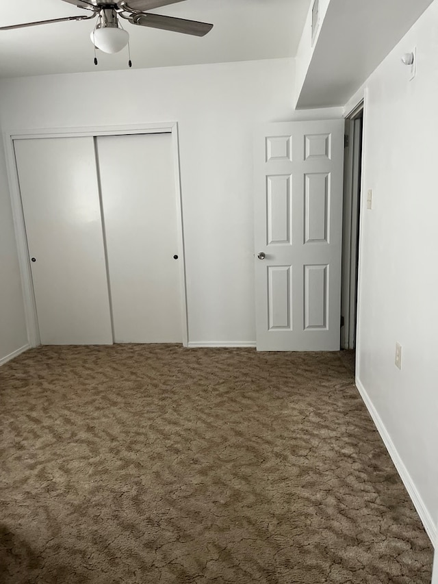 unfurnished bedroom with a closet, ceiling fan, and dark colored carpet