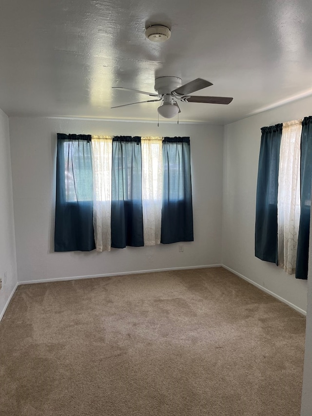 carpeted empty room featuring ceiling fan