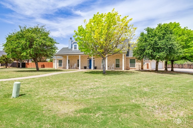 view of front of property with fence, a porch, a front yard, and stone siding
