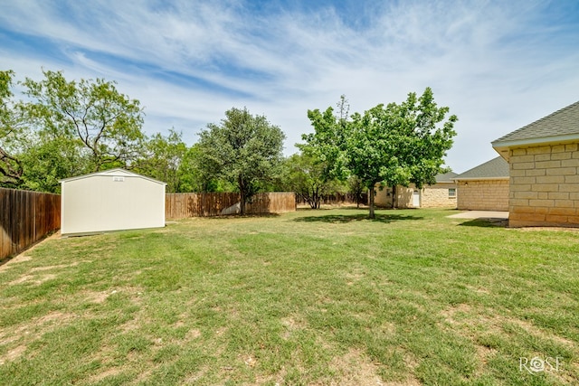 view of yard featuring an outbuilding, a storage shed, and a fenced backyard