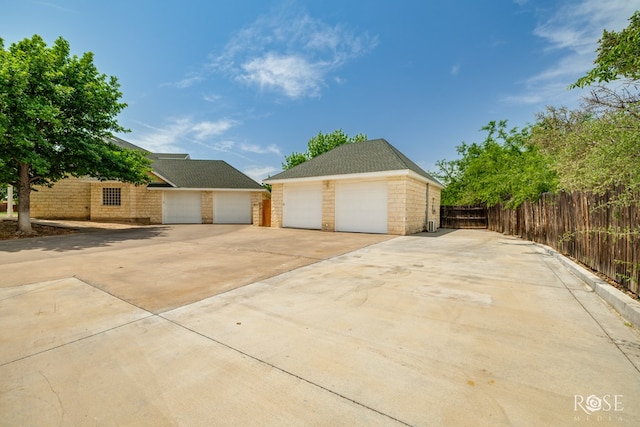 exterior space featuring an outdoor structure, a garage, and fence