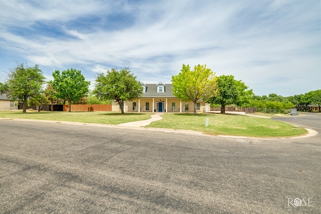 view of front of property with fence and a front lawn