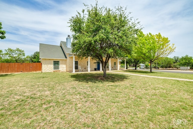 obstructed view of property featuring a chimney, fence, a front lawn, and roof with shingles