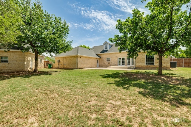 view of yard with fence, a patio, central AC unit, and french doors