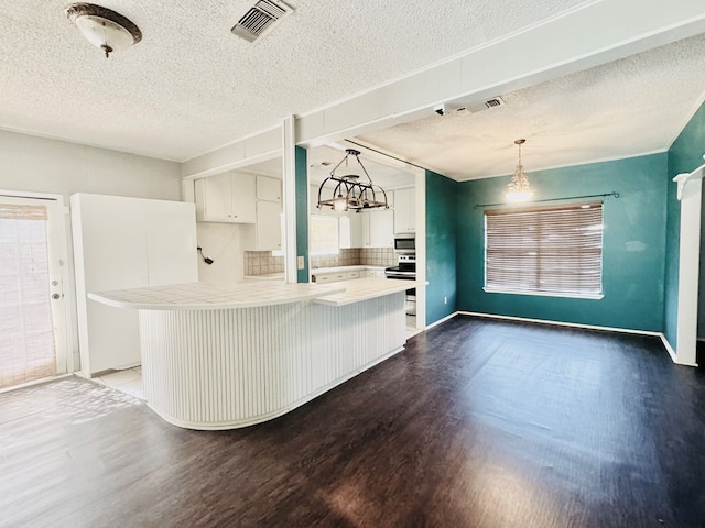 kitchen with decorative light fixtures, white cabinets, dark hardwood / wood-style flooring, kitchen peninsula, and stainless steel appliances