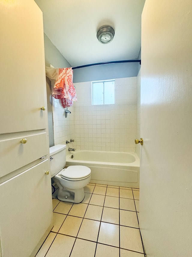 bathroom featuring tiled shower / bath, toilet, and tile patterned flooring