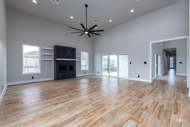 unfurnished living room featuring visible vents, a healthy amount of sunlight, light wood-style flooring, and a ceiling fan