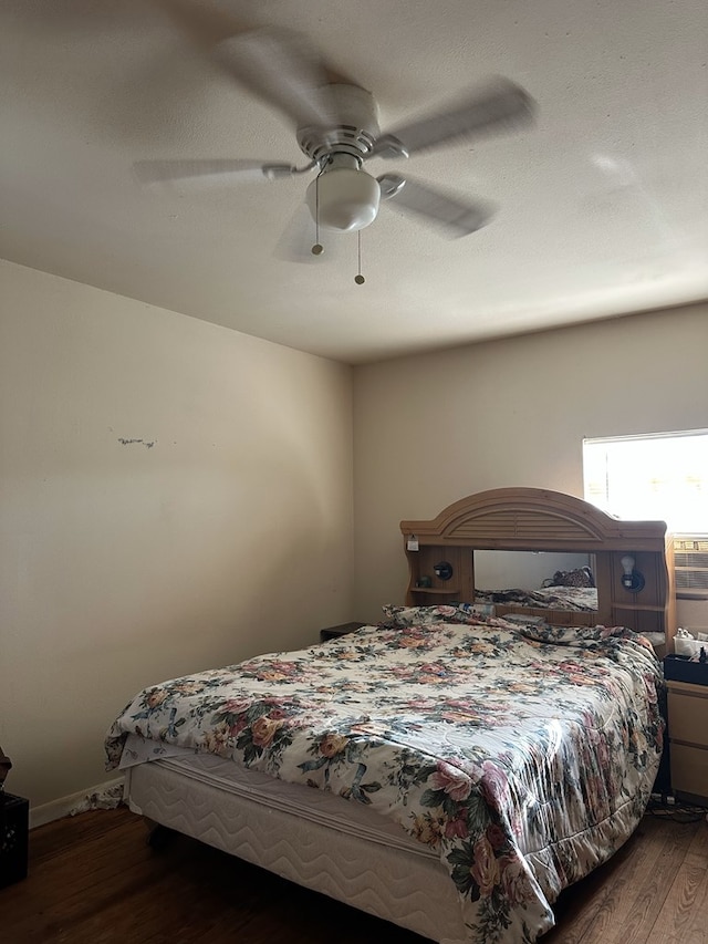 bedroom with dark hardwood / wood-style floors and ceiling fan