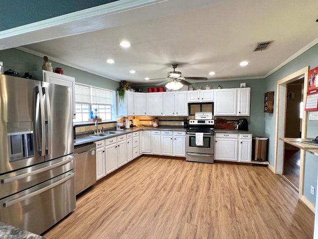 kitchen with sink, crown molding, stainless steel appliances, and white cabinets