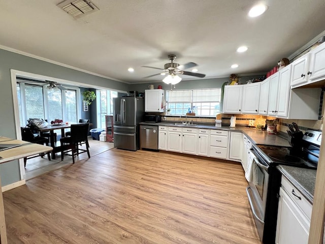 kitchen featuring stainless steel appliances, white cabinetry, sink, and light wood-type flooring