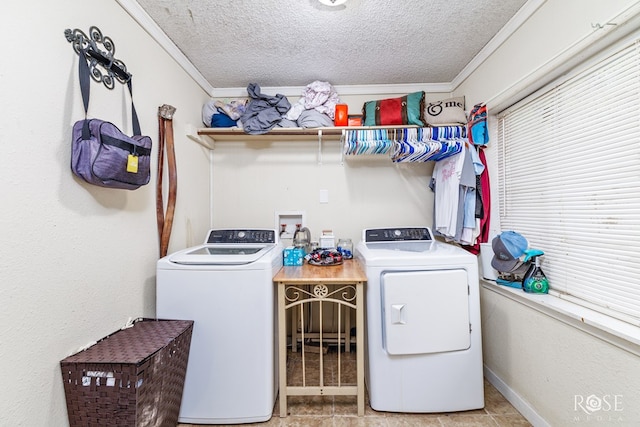 clothes washing area with crown molding, light tile patterned floors, a textured ceiling, and washer and clothes dryer