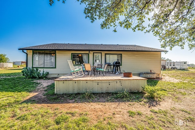 rear view of house with a wooden deck and a yard