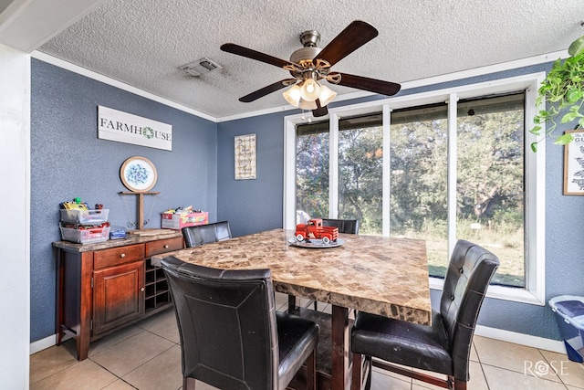 tiled dining space with crown molding and ceiling fan