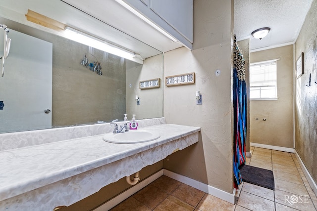 bathroom with sink, tile patterned floors, and a textured ceiling