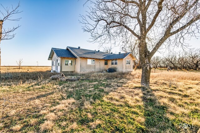 rear view of house featuring central AC unit