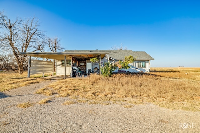 view of front of home featuring a carport and a rural view