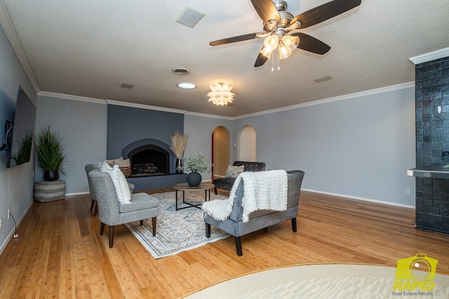 2720 Tanglewood Dr, San Angelo, TX 76904 - living area with a fireplace with raised hearth, wood finished floors, baseboards, ceiling fan, and a textured ceiling