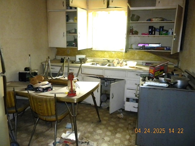 kitchen with open shelves, light countertops, white cabinets, and light floors