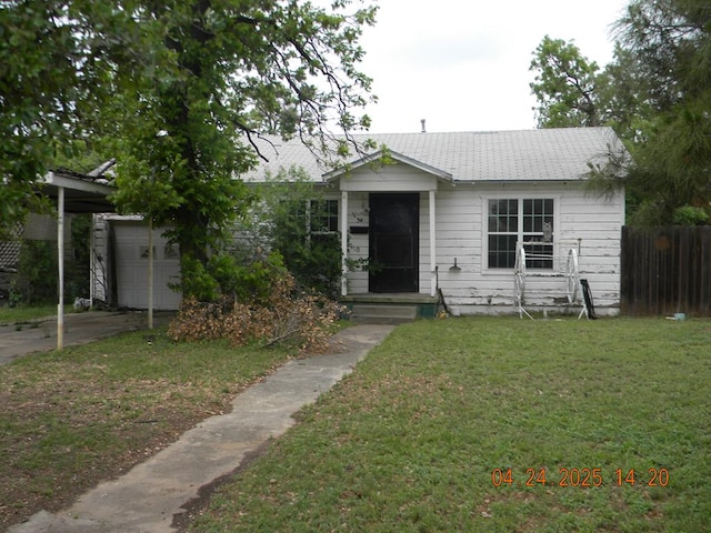 view of front of home featuring concrete driveway, a front lawn, and fence