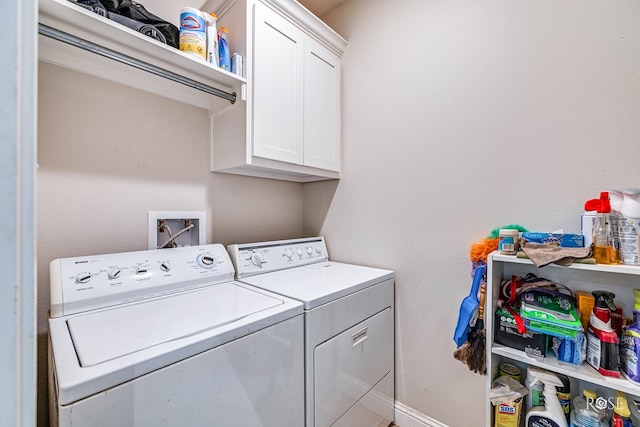 clothes washing area with cabinets and independent washer and dryer