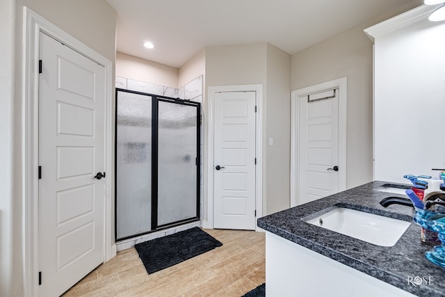 bathroom featuring vanity, a shower with door, and wood-type flooring