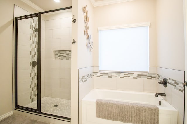 bathroom featuring ornamental molding and separate shower and tub