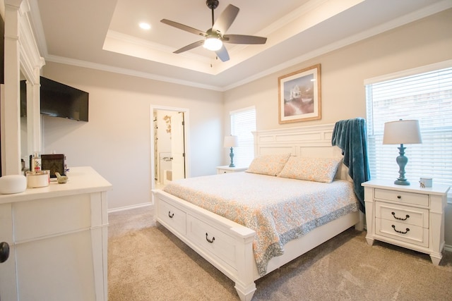 carpeted bedroom with connected bathroom, crown molding, a raised ceiling, and ceiling fan