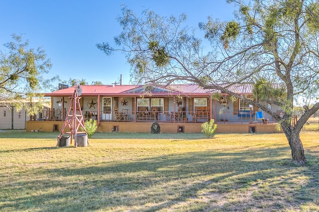 ranch-style home with a front yard, covered porch, and metal roof