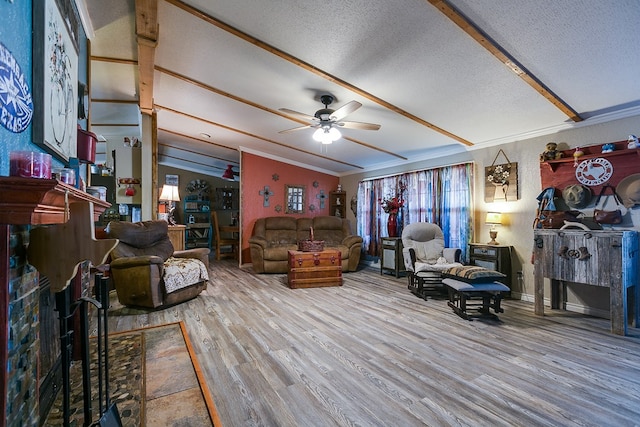 living area with a textured ceiling, a ceiling fan, ornamental molding, wood finished floors, and vaulted ceiling with beams