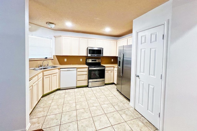 kitchen featuring light tile patterned floors, a sink, stainless steel appliances, light countertops, and a textured ceiling