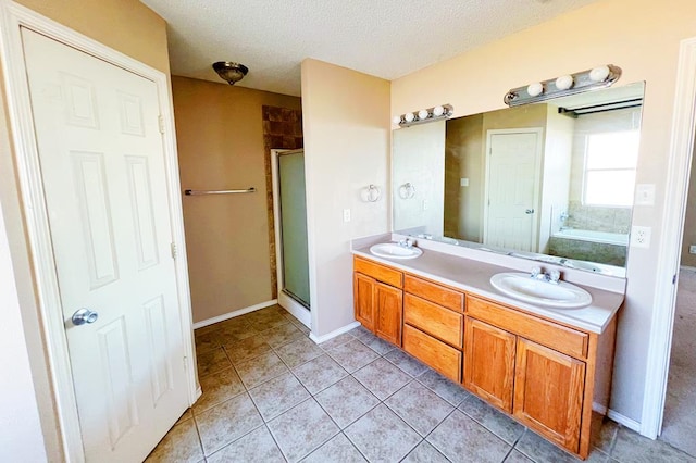 bathroom with a stall shower, a textured ceiling, and a sink