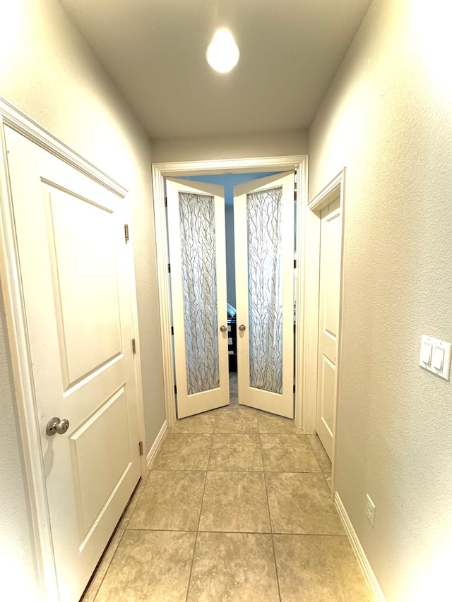 hallway featuring light tile patterned floors and french doors