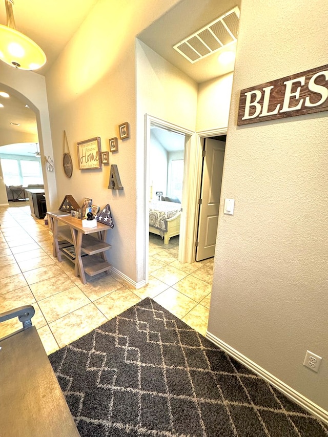 corridor featuring a healthy amount of sunlight and tile patterned flooring