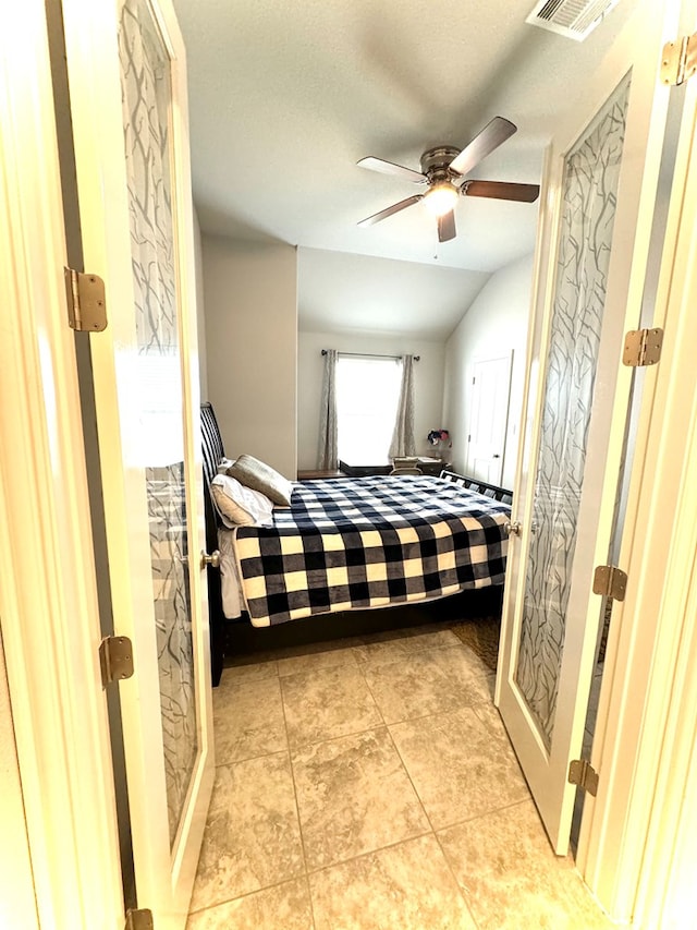 bedroom featuring lofted ceiling, ceiling fan, and light tile patterned flooring