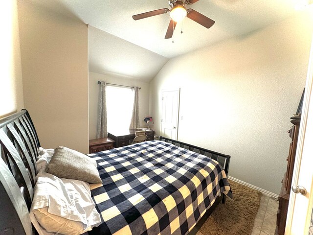 bedroom featuring tile patterned flooring, vaulted ceiling, and ceiling fan