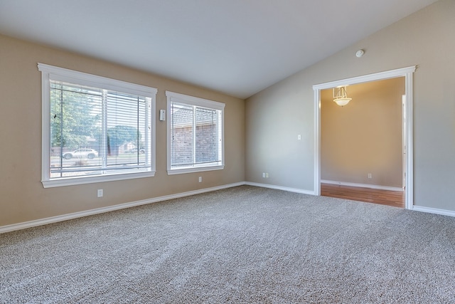 empty room with lofted ceiling and carpet flooring