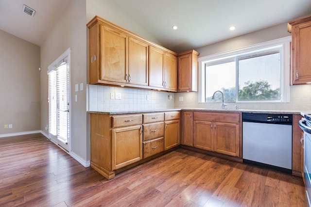 kitchen featuring sink, vaulted ceiling, dishwasher, a wealth of natural light, and hardwood / wood-style flooring