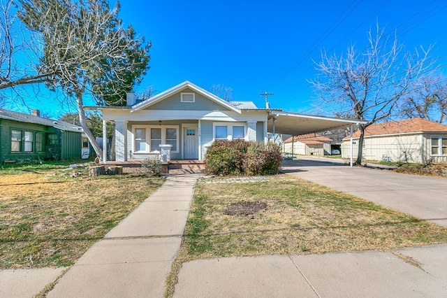 view of front facade featuring a carport, a porch, and a front yard