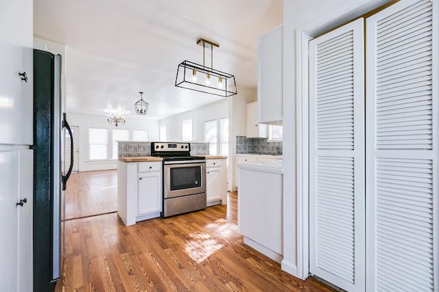 kitchen featuring pendant lighting, decorative backsplash, white cabinets, and appliances with stainless steel finishes