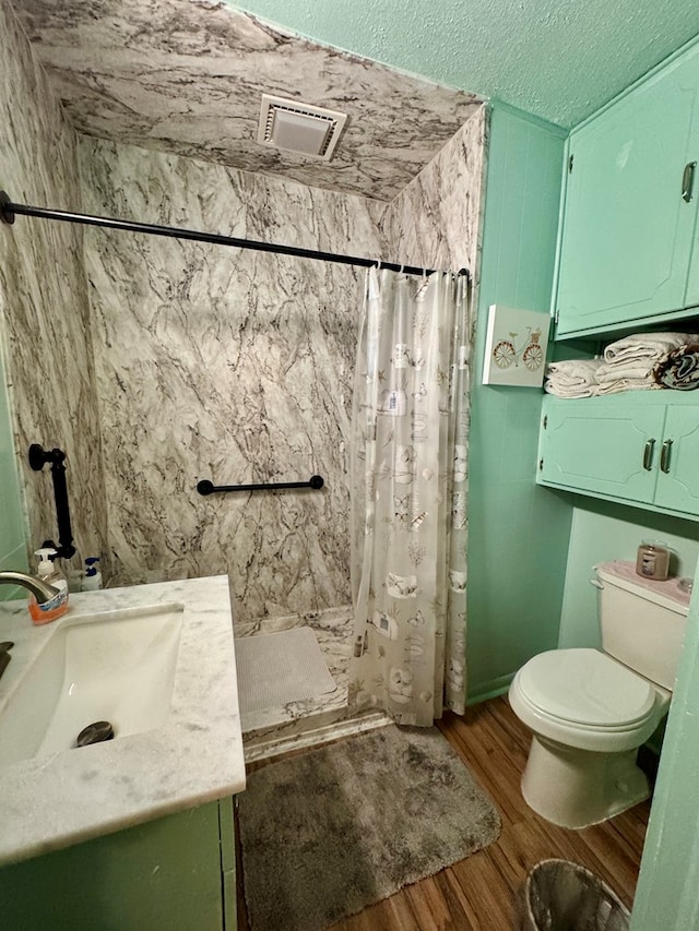 bathroom featuring hardwood / wood-style flooring, vanity, toilet, a textured ceiling, and a shower with shower curtain