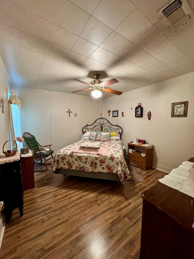 bedroom with dark hardwood / wood-style floors and ceiling fan