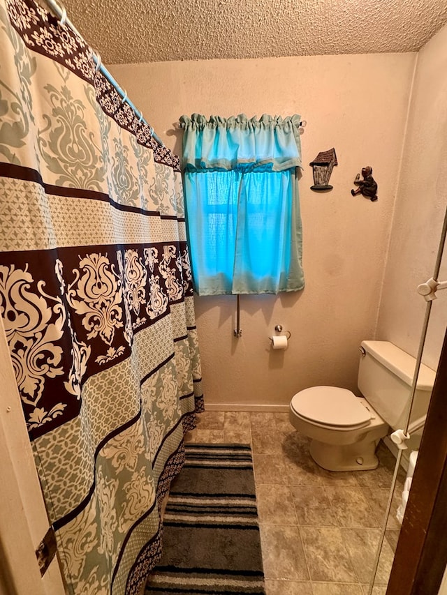 bathroom with a textured ceiling and toilet