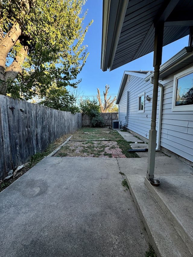 view of yard featuring central AC unit and a patio